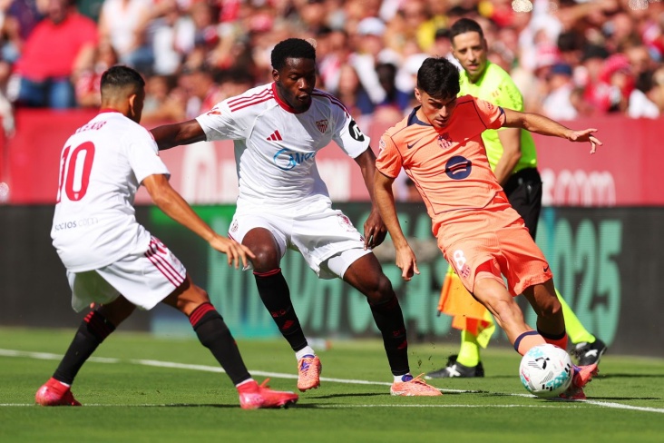 Игроки Севильи пытаются отобрать мяч у соперника