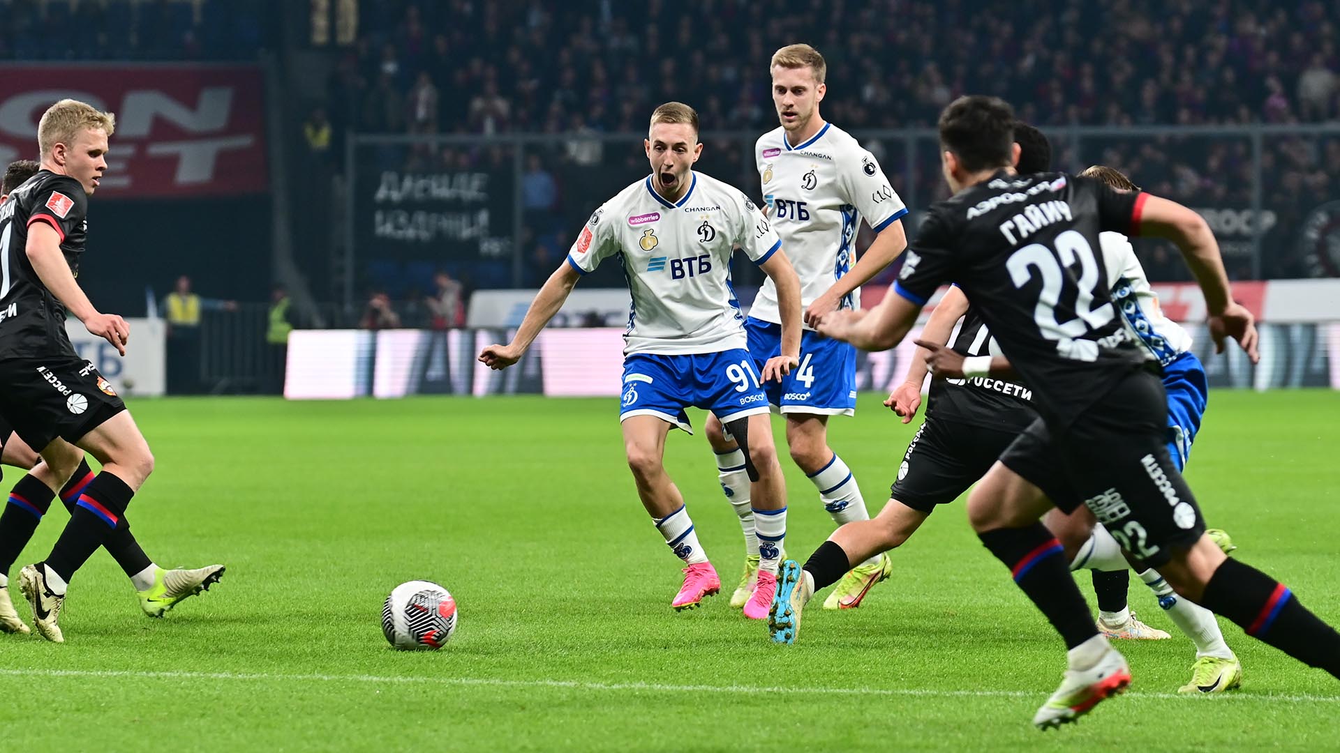 футболист московского Динамо пытается обвести своих соперников