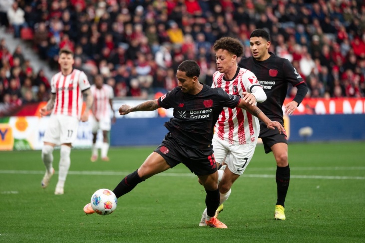 Игрок Байера пытается пробить по воротам соперника